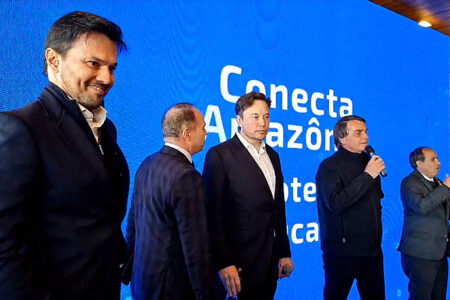 Fábio Faria (em primeiro plano), Elon Musk (ao centro) e Bolsonaro, junto de intérpretes: visita aconteceu no dia em que revista divulgou denúncia de assédio contra o bilionário. Foto: Reprodução/Facebook/Jair Bolsonaro

